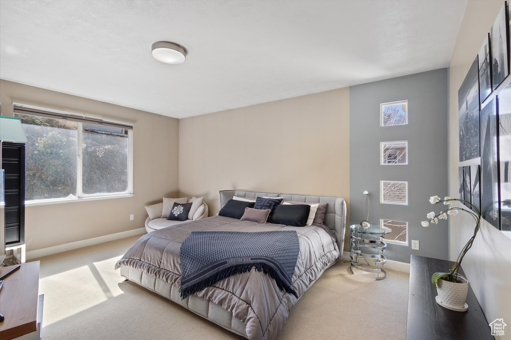 Carpeted bedroom with multiple windows and baseboards