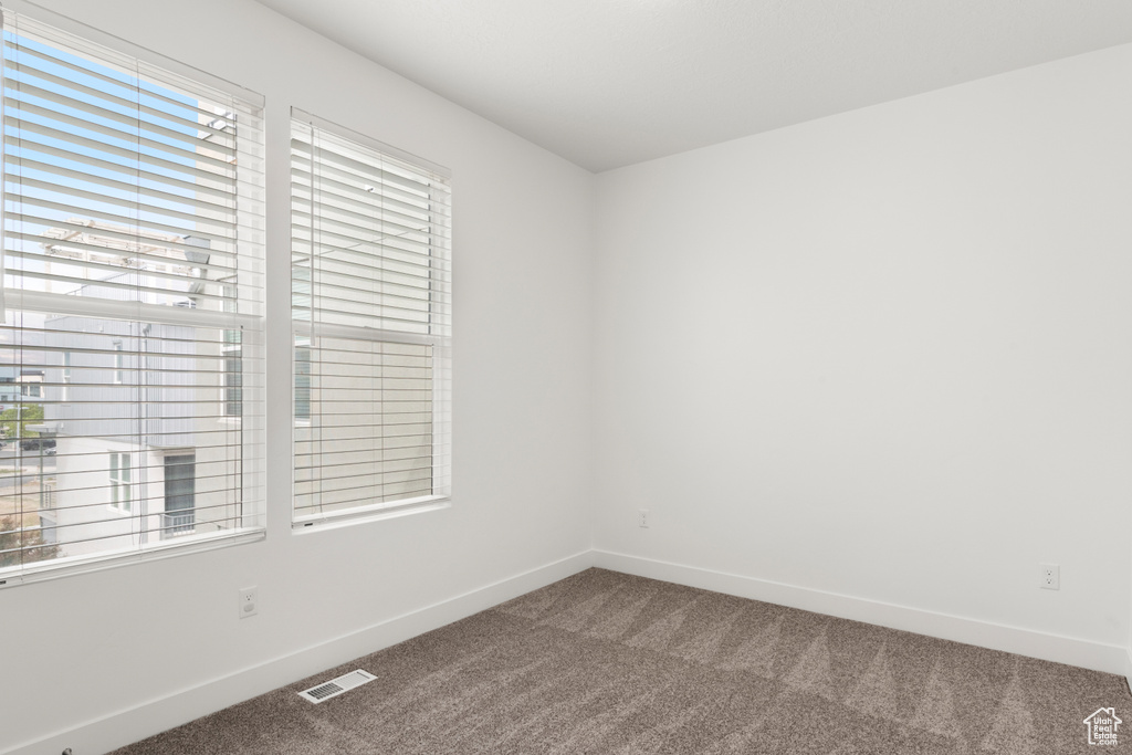 Carpeted spare room with baseboards
