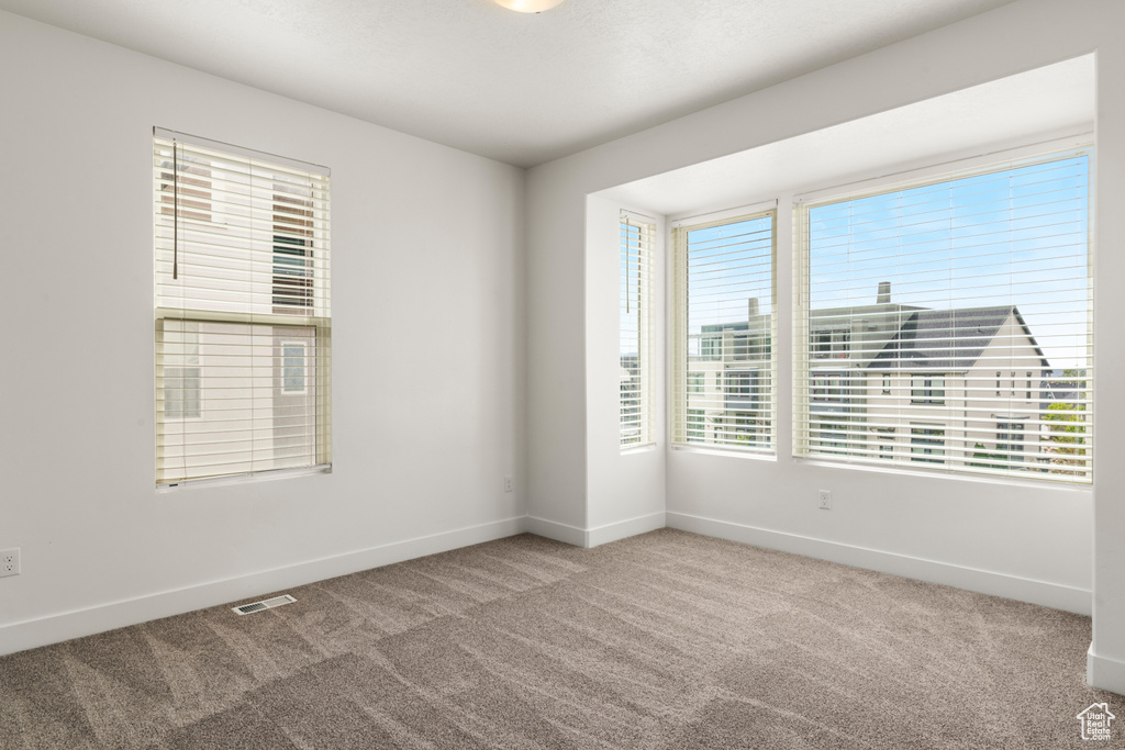 Carpeted empty room featuring baseboards