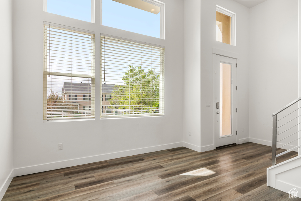 Foyer featuring wood finished floors, baseboards, and stairway