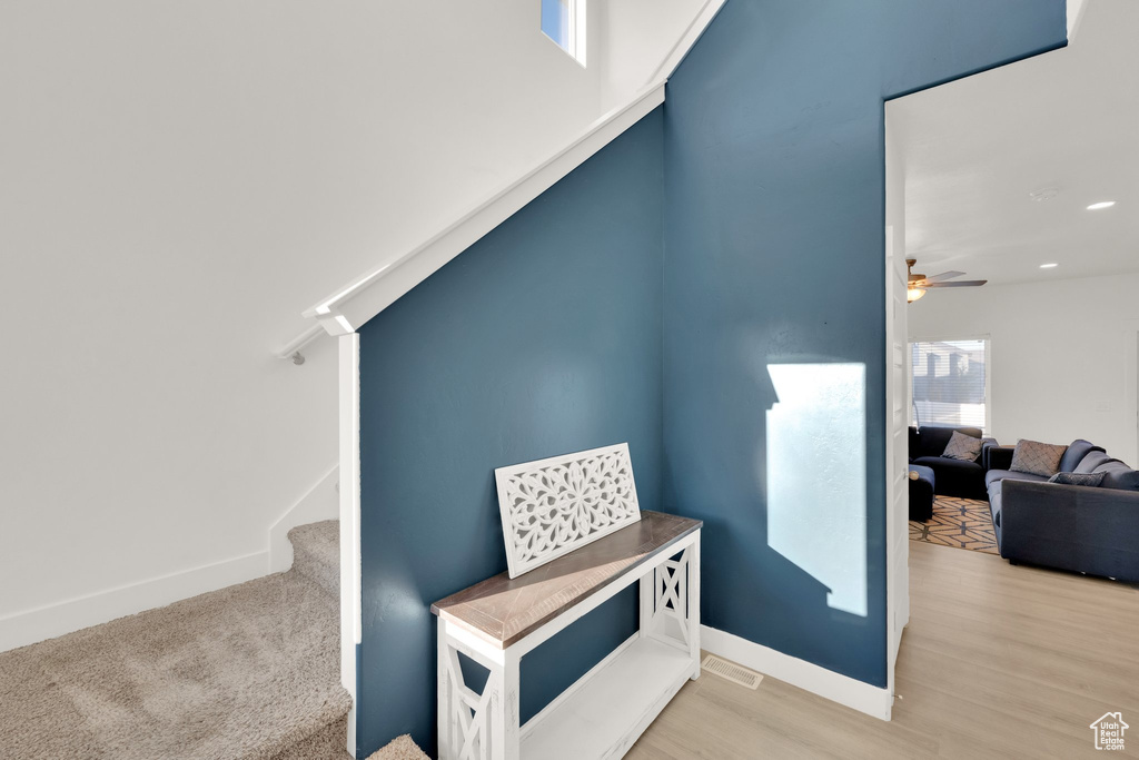 Staircase featuring baseboards, ceiling fan, wood finished floors, and recessed lighting