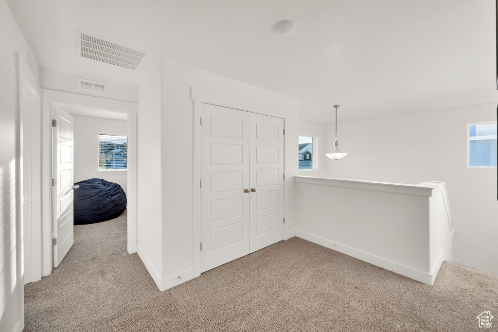 Unfurnished bedroom featuring carpet floors, multiple windows, and a closet