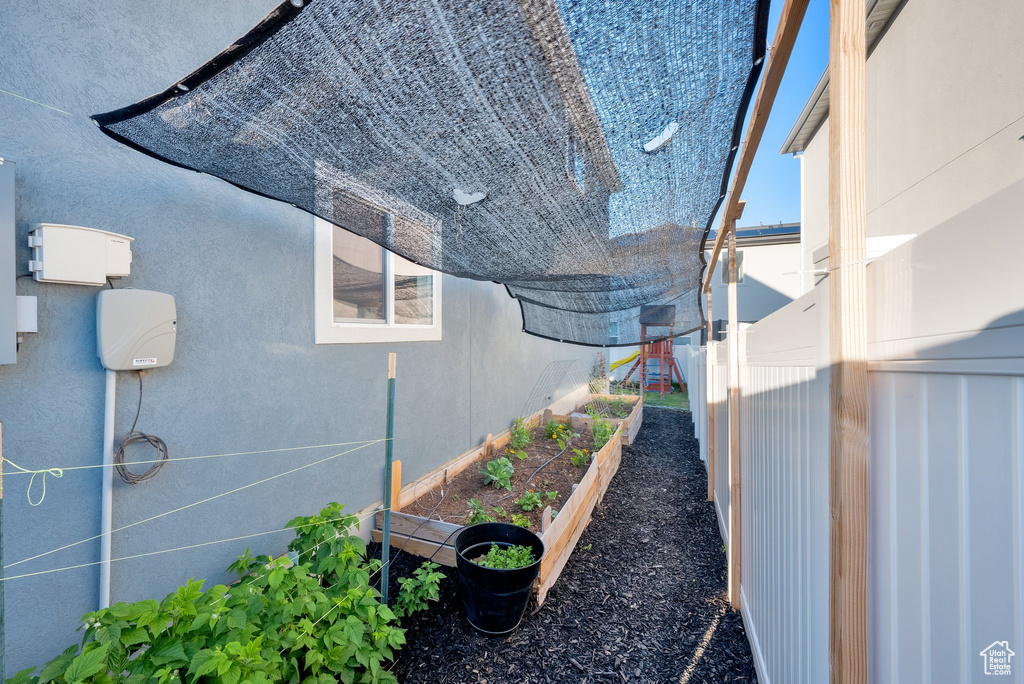 View of side of property with a vegetable garden and stucco siding