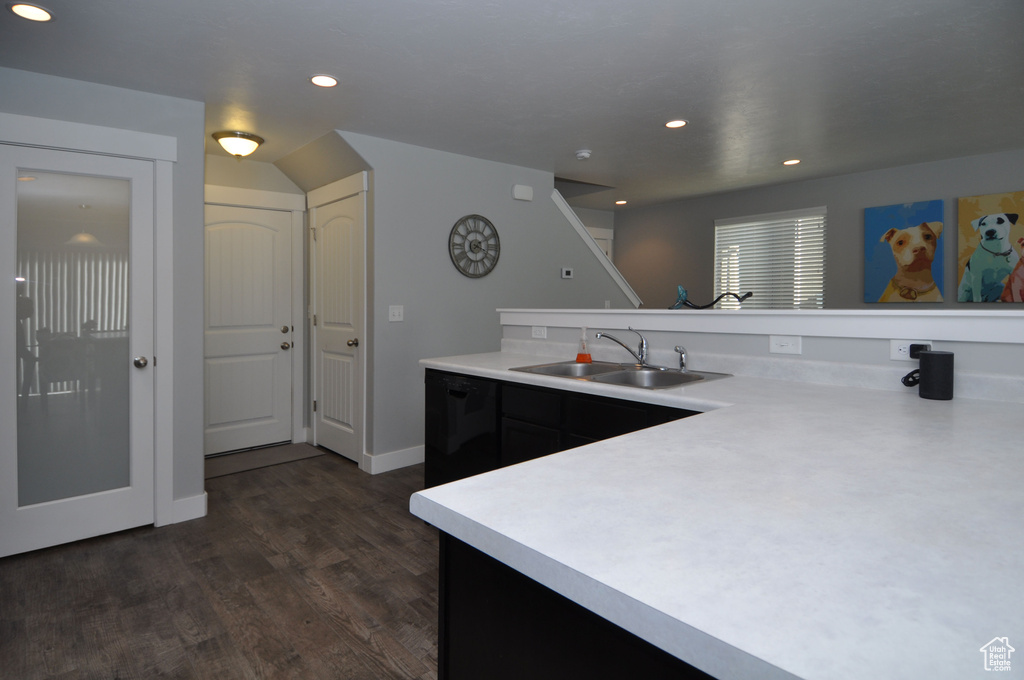 Kitchen with a sink, light countertops, recessed lighting, dark wood-style flooring, and dark cabinets