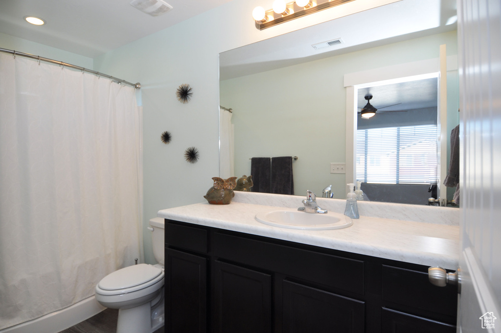 Full bath featuring a ceiling fan, toilet, vanity, recessed lighting, and wood finished floors