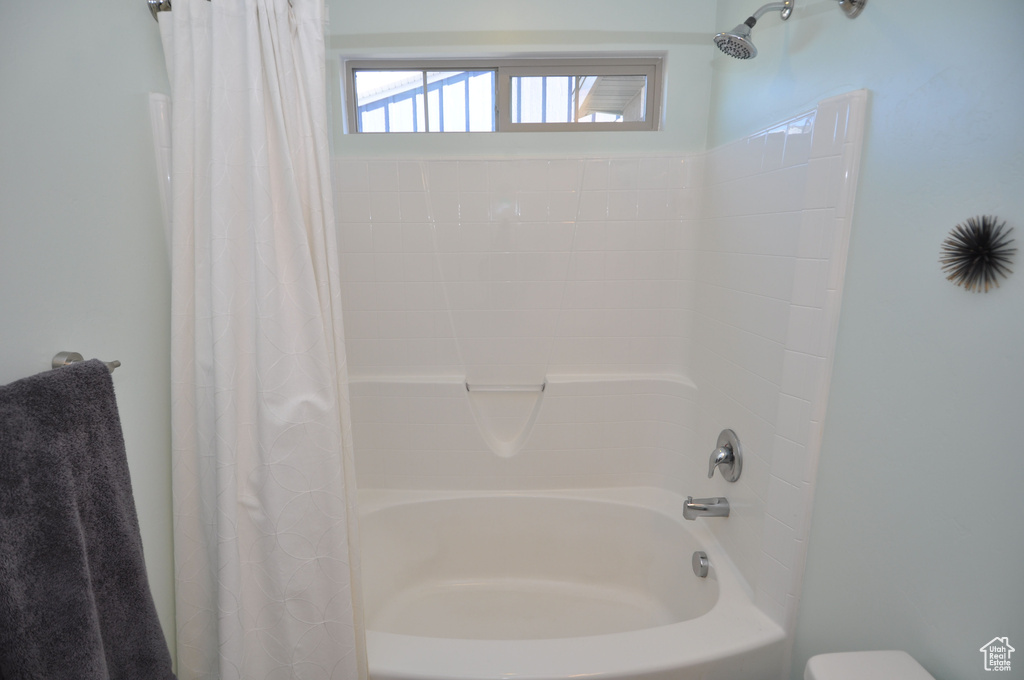 Bathroom with shower / bath combo with shower curtain and toilet