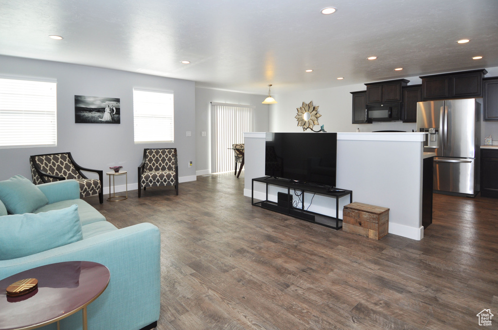 Living area featuring plenty of natural light, dark wood-type flooring, baseboards, and recessed lighting