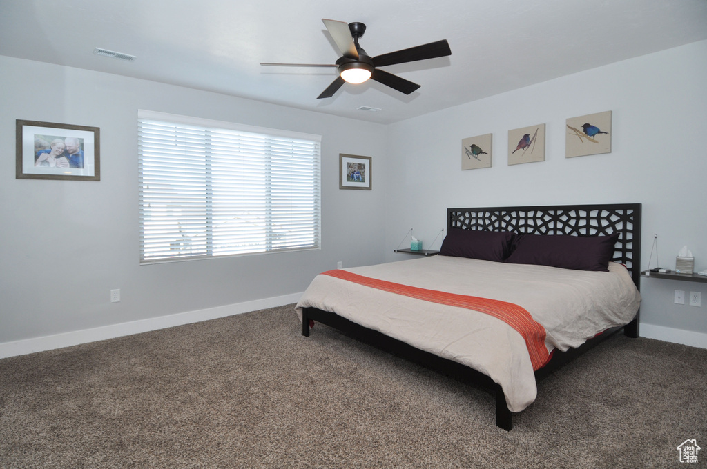 Bedroom with carpet flooring, baseboards, and a ceiling fan
