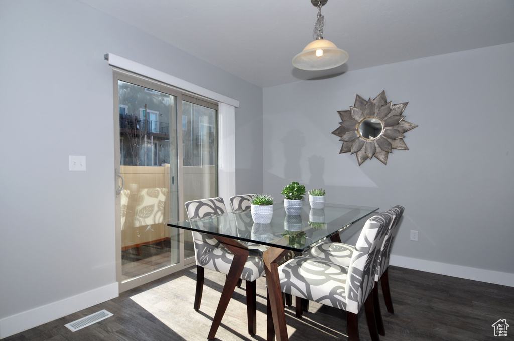 Dining area with dark wood-style floors and baseboards