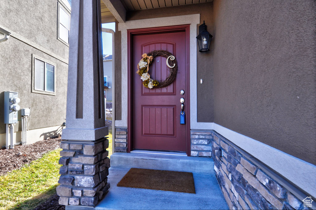 Entrance to property with stucco siding and stone siding