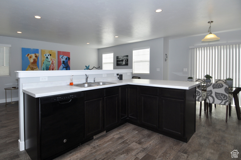 Kitchen featuring dishwasher, a sink, dark wood-style floors, light countertops, and recessed lighting