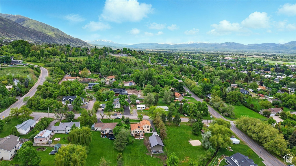 Aerial overview of property's location with a mountainous background and nearby suburban area