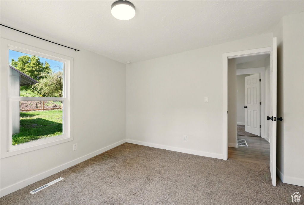 Carpeted spare room with baseboards