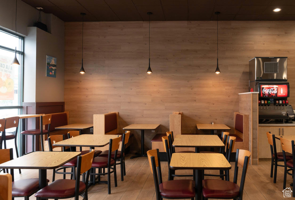 Dining area with wood walls, plenty of natural light, light wood finished floors, and recessed lighting