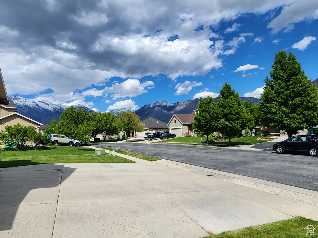 View of road featuring a mountain view, sidewalks, and a residential view