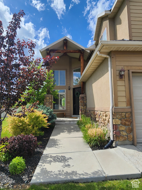 Entrance to property featuring stone siding and stucco siding