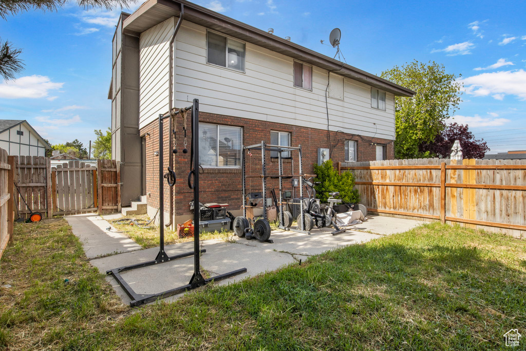 Rear view of property with brick siding and a gate
