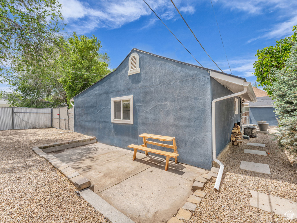 Back of house with stucco siding, a patio area, and a gate