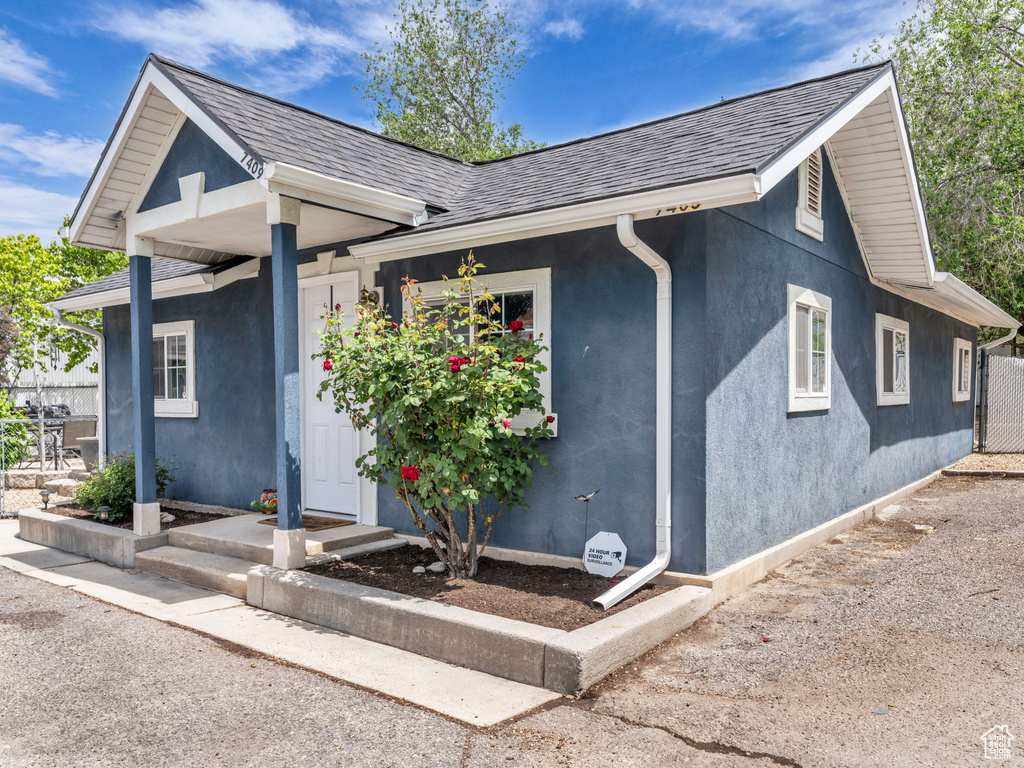 Ranch-style home featuring stucco siding and a shingled roof