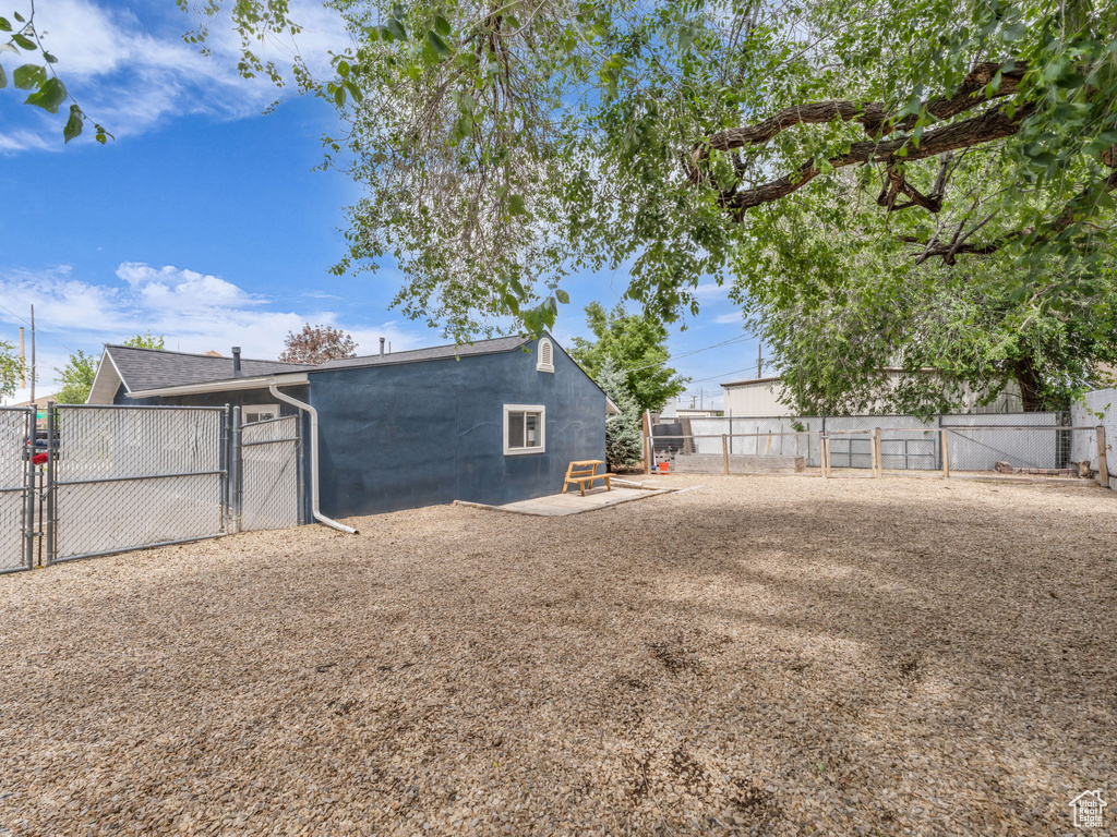 Back of house with a gate, a fenced backyard, and concrete block siding