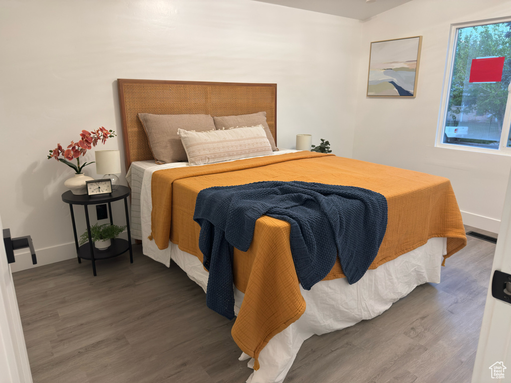 Bedroom with wood finished floors and baseboards
