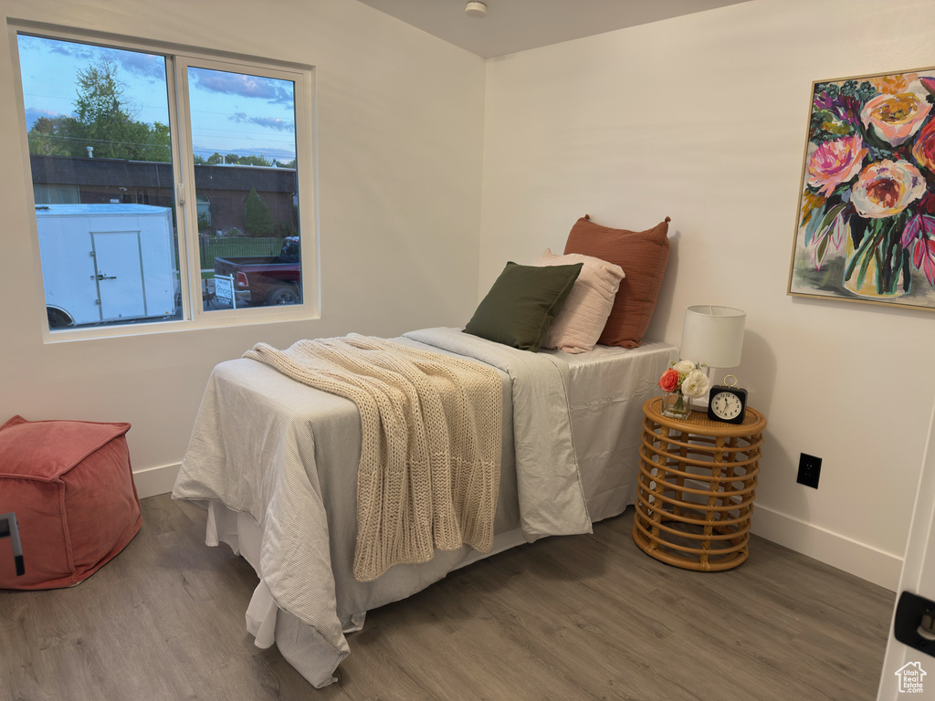 Bedroom with wood finished floors and baseboards