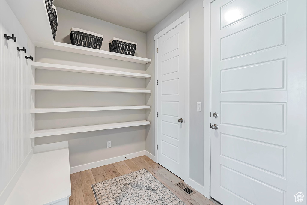 Doorway with light wood-type flooring and baseboards