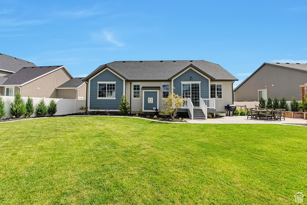 Rear view of property featuring a patio and roof with shingles