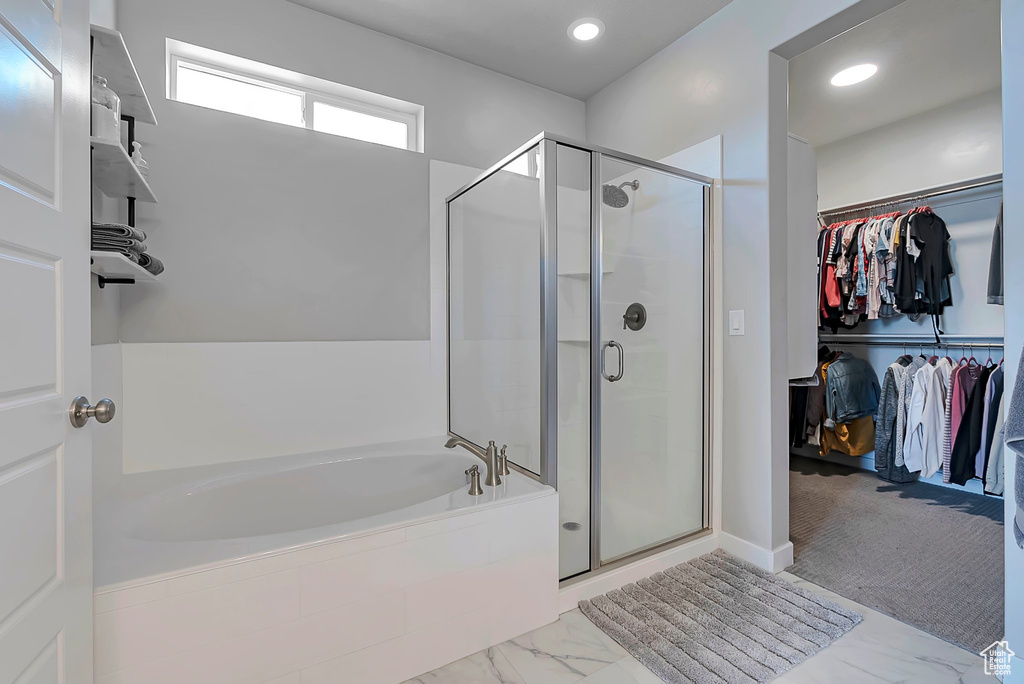 Full bathroom with a walk in closet, a shower stall, a bath, marble finish floors, and recessed lighting