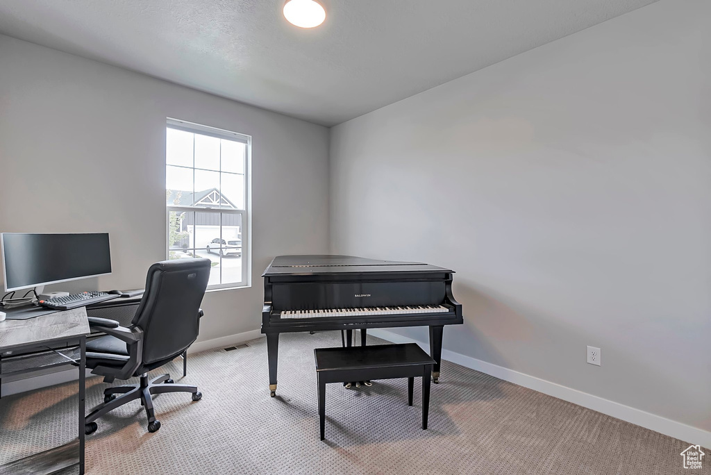 Home office with baseboards, light carpet, and healthy amount of natural light