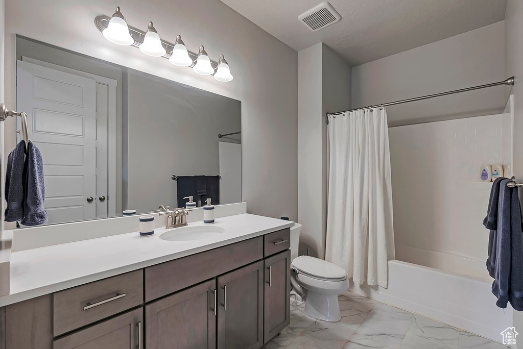 Full bath featuring marble finish floors, toilet, shower / tub combo, and vanity