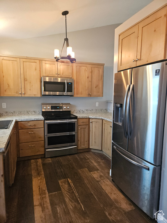 Kitchen with appliances with stainless steel finishes, light brown cabinets, dark wood-style flooring, a chandelier, and vaulted ceiling