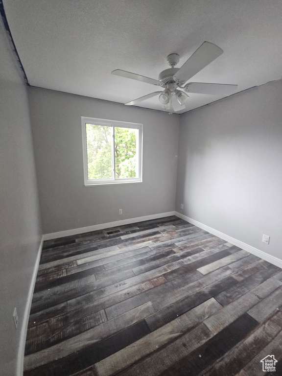 Spare room featuring ceiling fan, baseboards, and wood finished floors