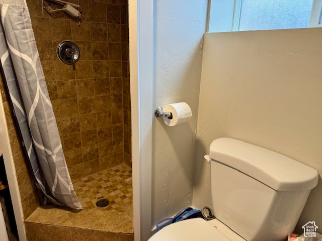 Full bathroom with toilet and a tile shower