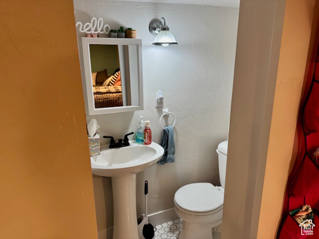 Half bathroom featuring toilet and baseboards