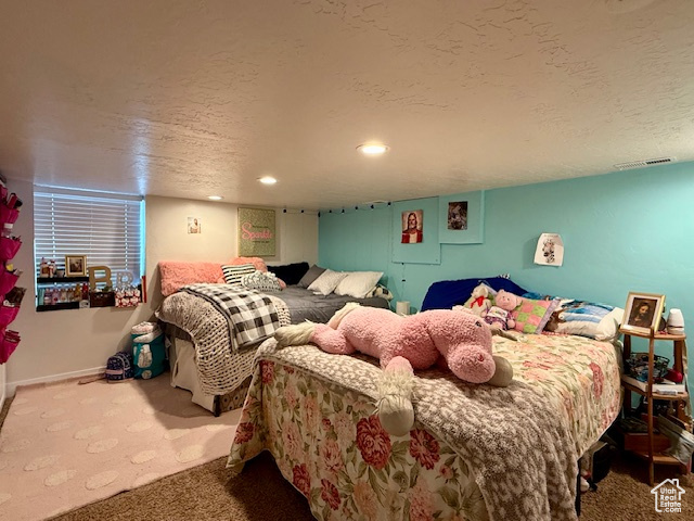 Carpeted bedroom with recessed lighting and a textured ceiling