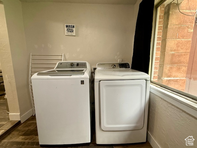 Washroom with washer and clothes dryer and dark wood-style flooring