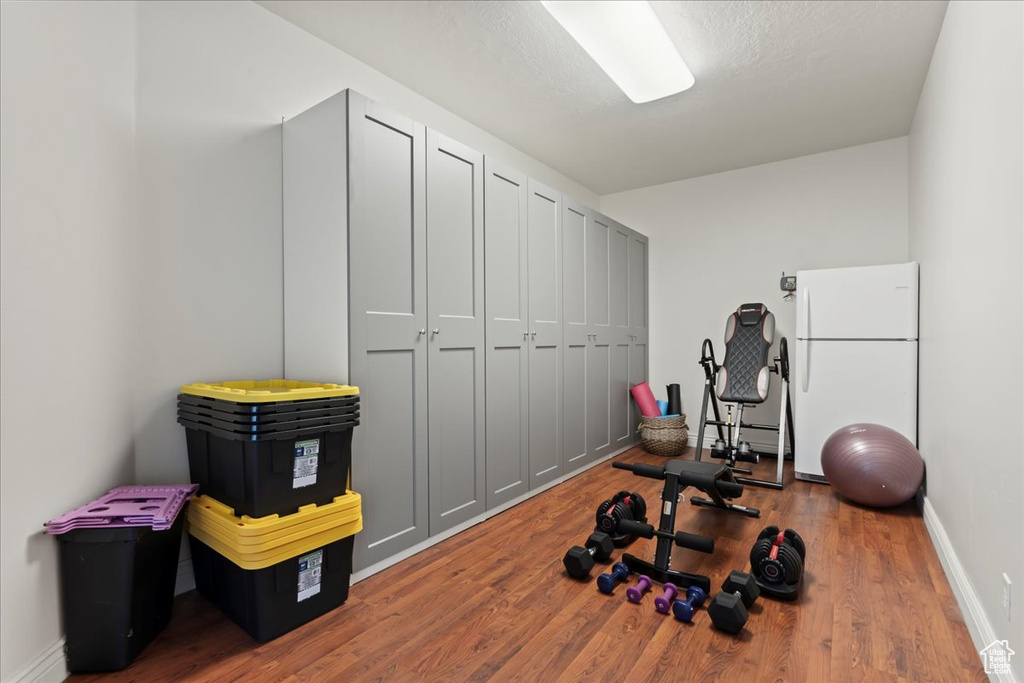 Exercise room with wood finished floors, baseboards, and baseboard heating