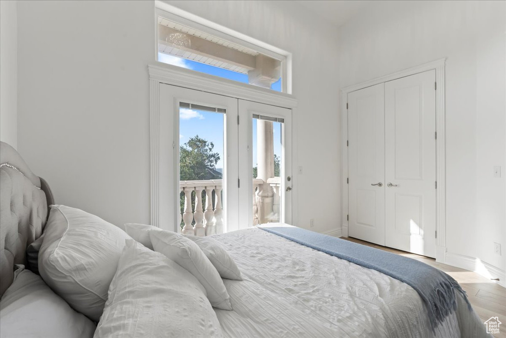 Bedroom featuring access to outside, wood finished floors, baseboards, and a closet