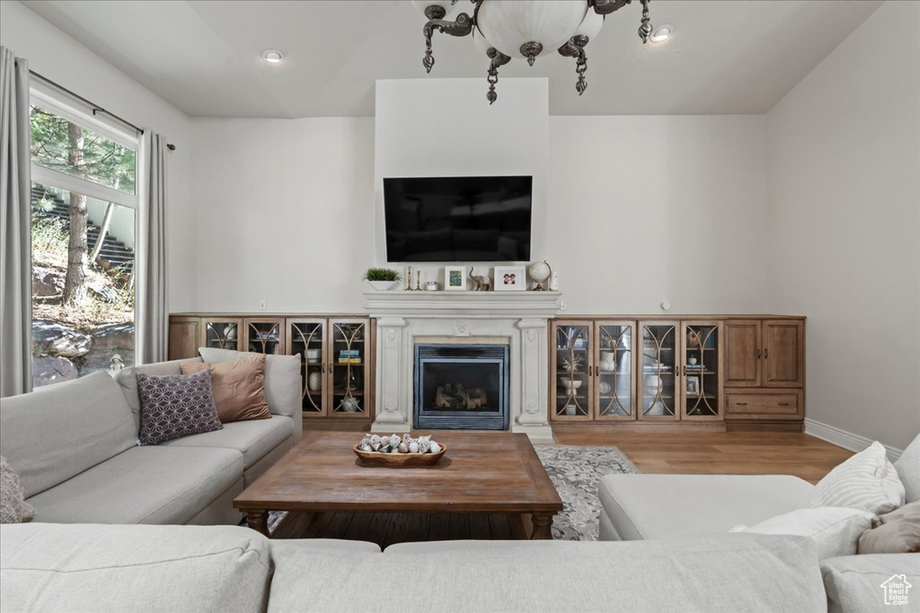 Living area featuring wood finished floors, a fireplace, and baseboards