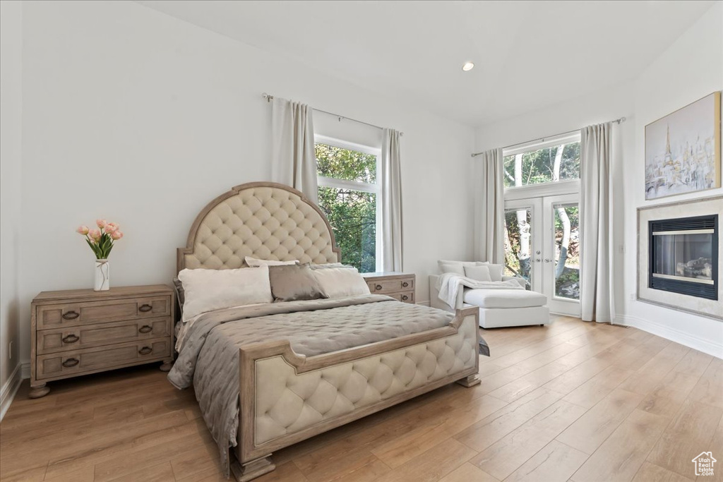Bedroom featuring access to exterior, multiple windows, light wood-type flooring, baseboards, and recessed lighting