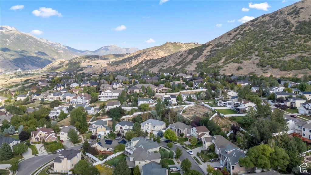 Aerial overview of property's location with a mountainous background and nearby suburban area