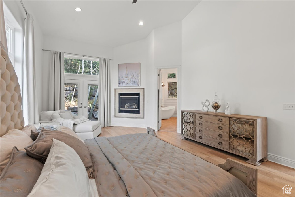 Bedroom with access to exterior, baseboards, light wood-style floors, recessed lighting, and french doors