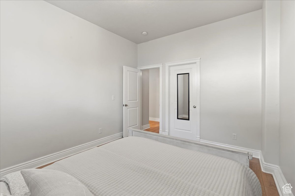 Bedroom with wood finished floors and baseboards