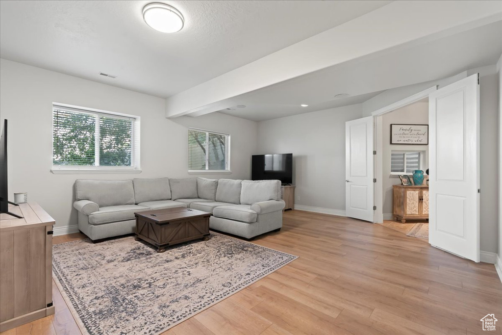 Living room featuring light wood-style flooring and baseboards