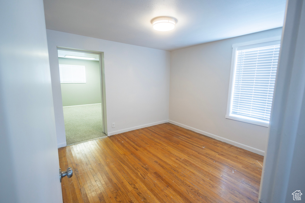 Spare room with hardwood / wood-style floors and baseboards
