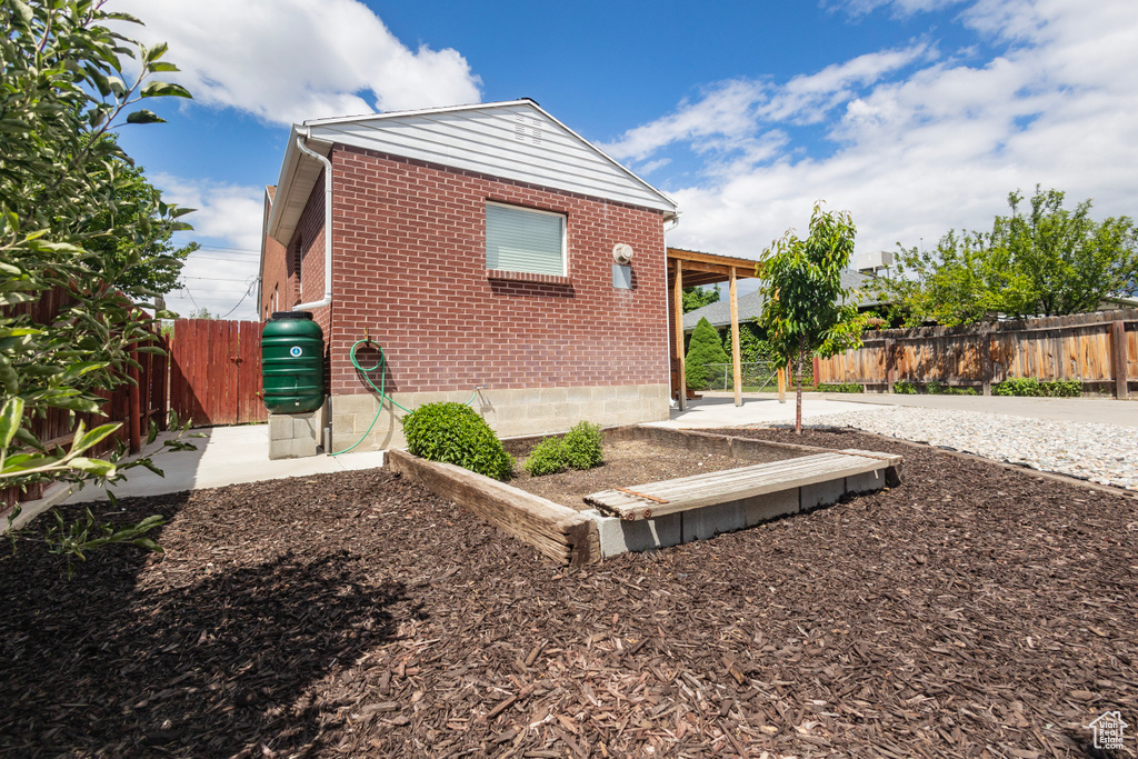 Back of property featuring brick siding, a fenced backyard, and a patio area