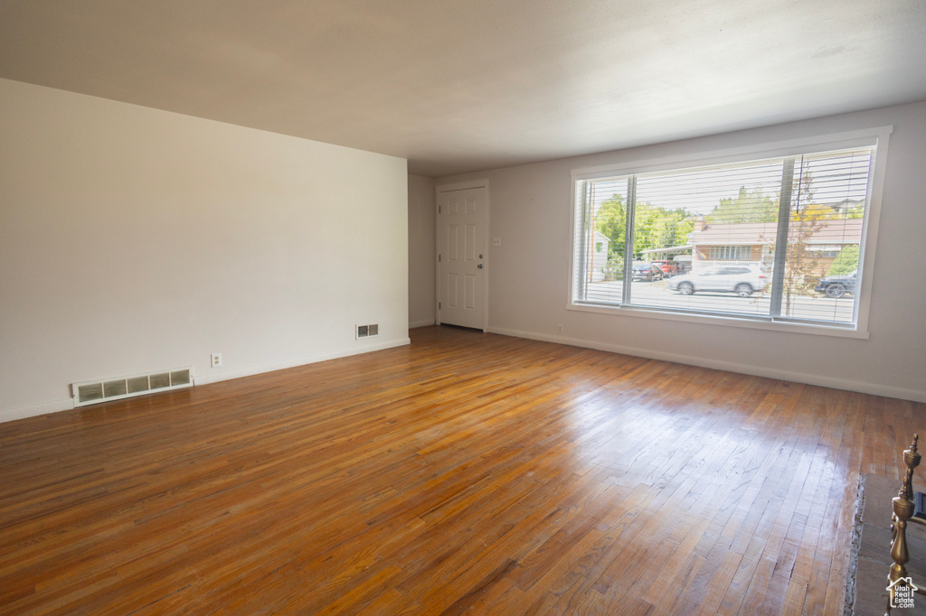 Empty room featuring hardwood / wood-style flooring and baseboards