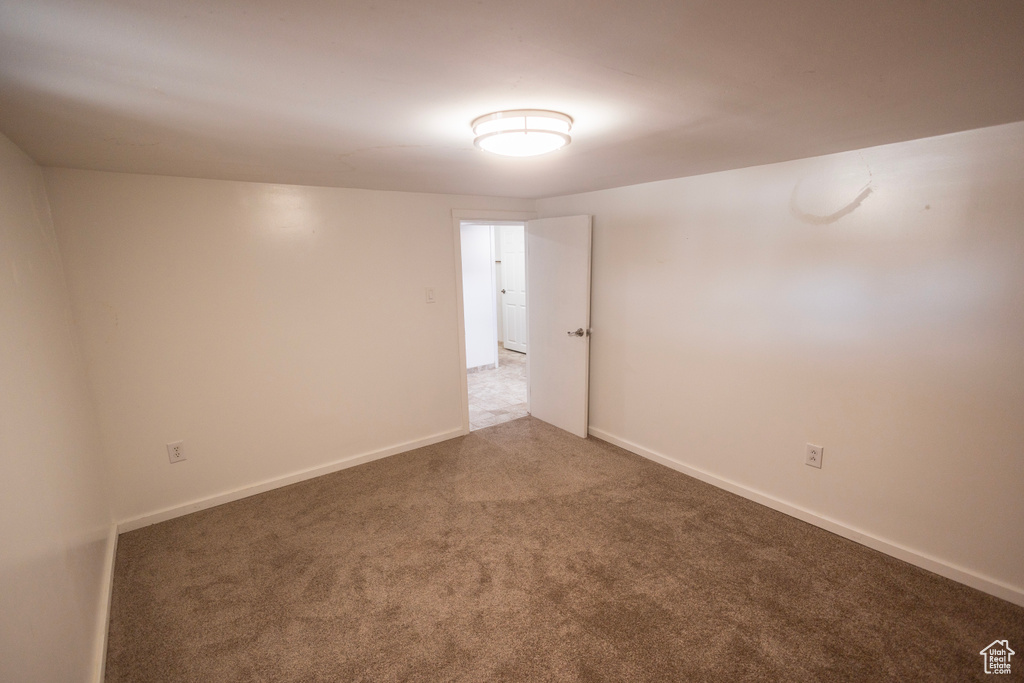 Carpeted empty room featuring baseboards