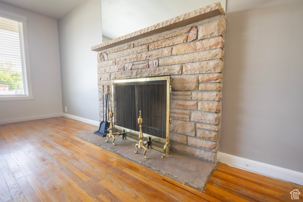 Detailed view of wood finished floors, baseboards, and a fireplace
